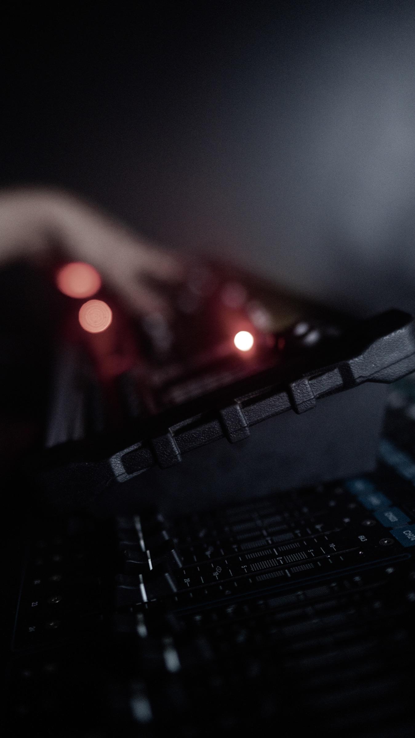 A hand on a lit mixer in the dark