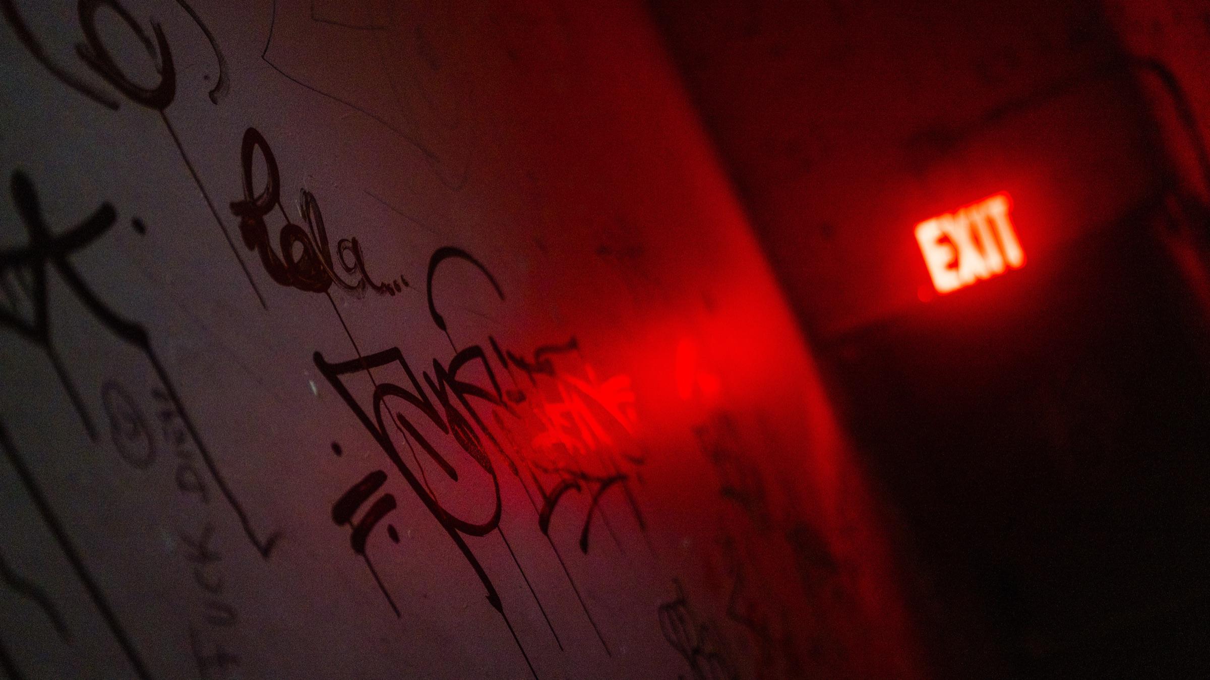 Graffiti wall under a red exit sign