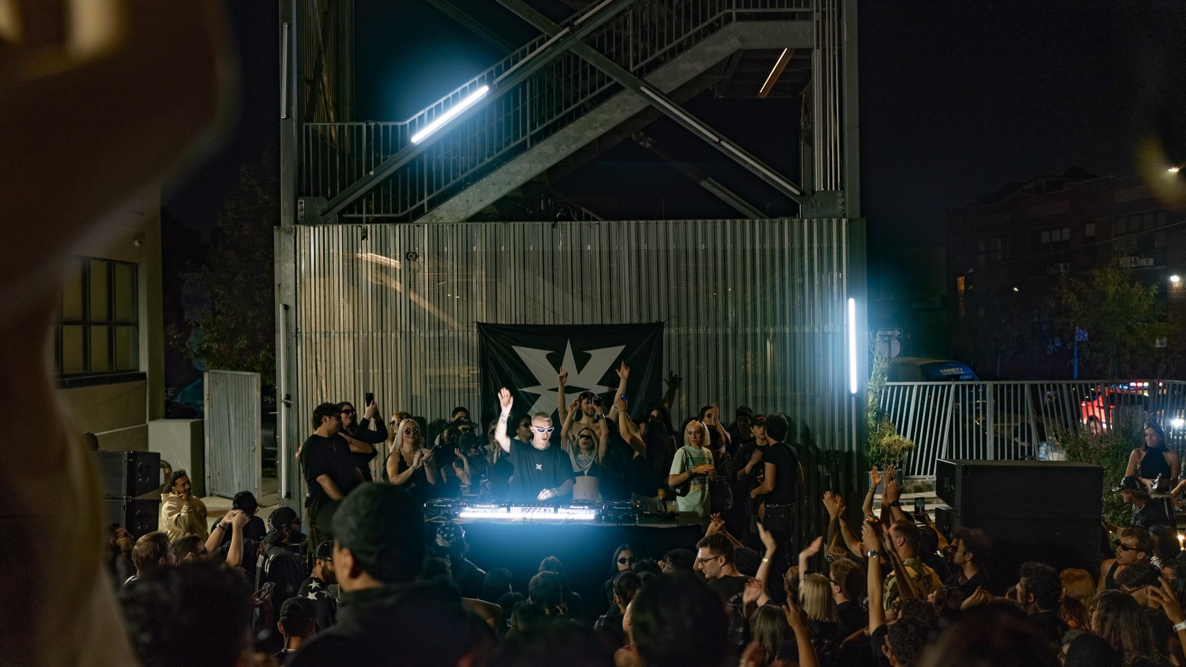 Wide view of the courtyard, crowd and lit stage banner