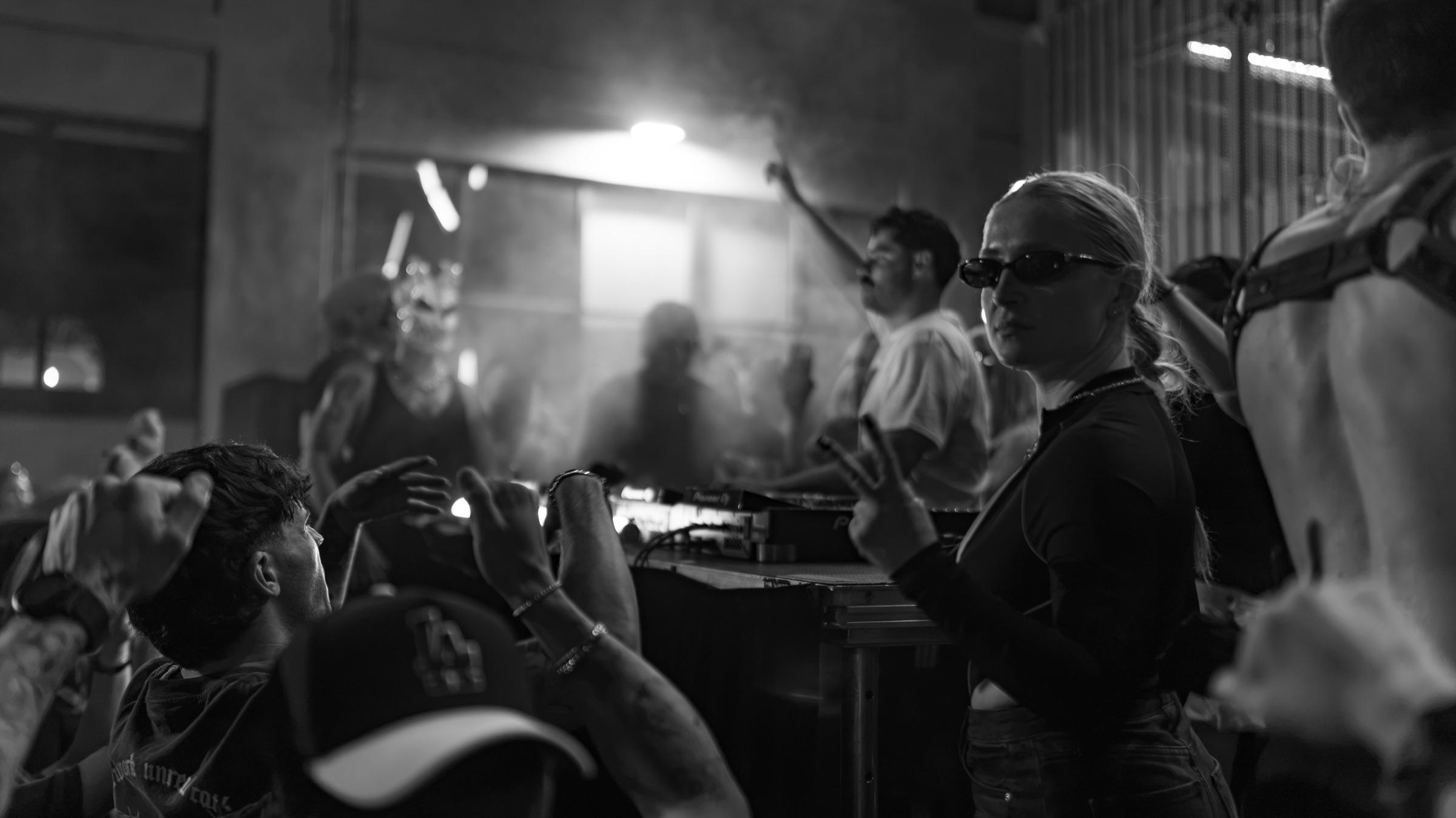 Black-and-white: the booth in smoke, crowd around it