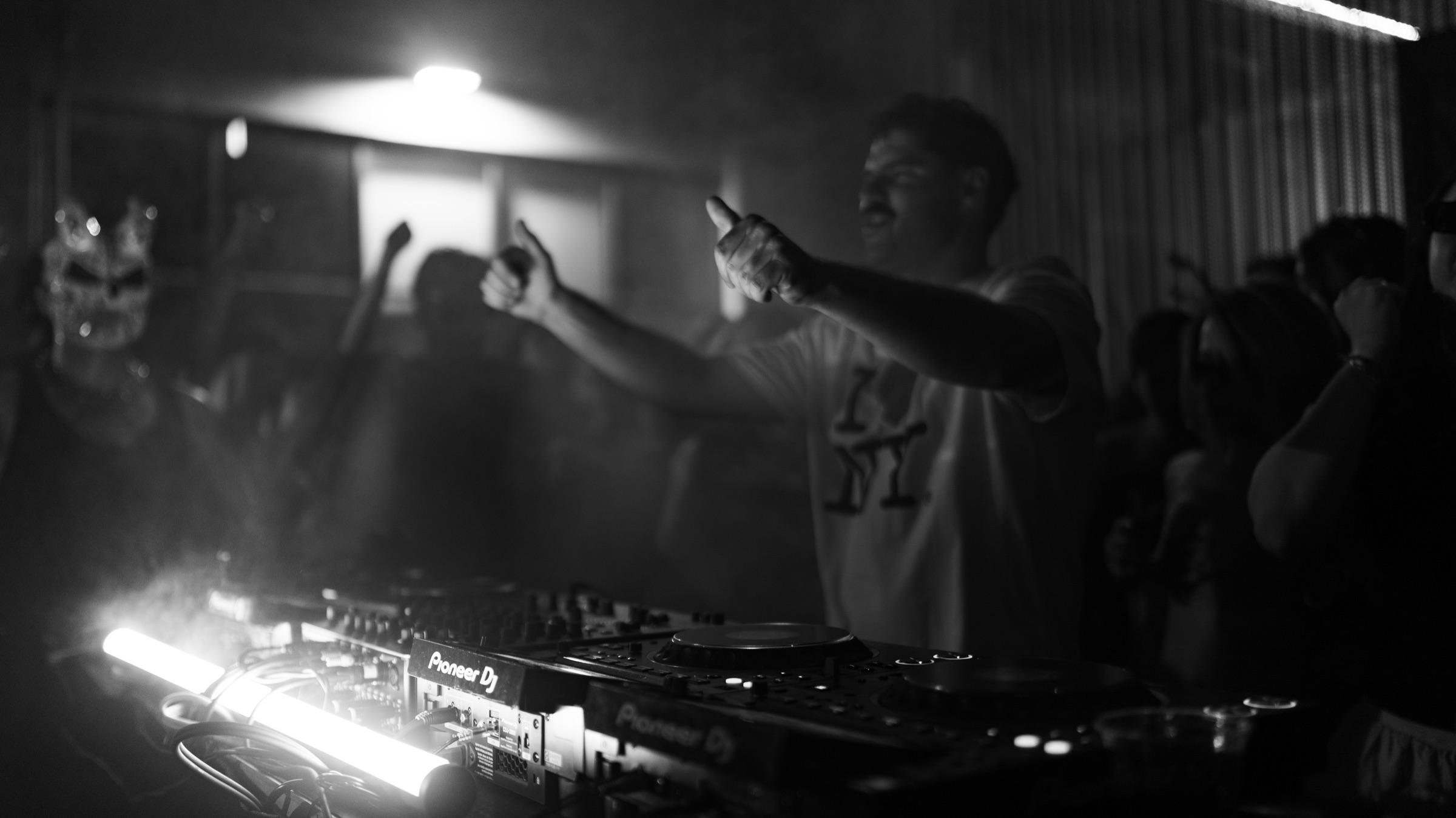 Black-and-white: DJ pointing at the crowd