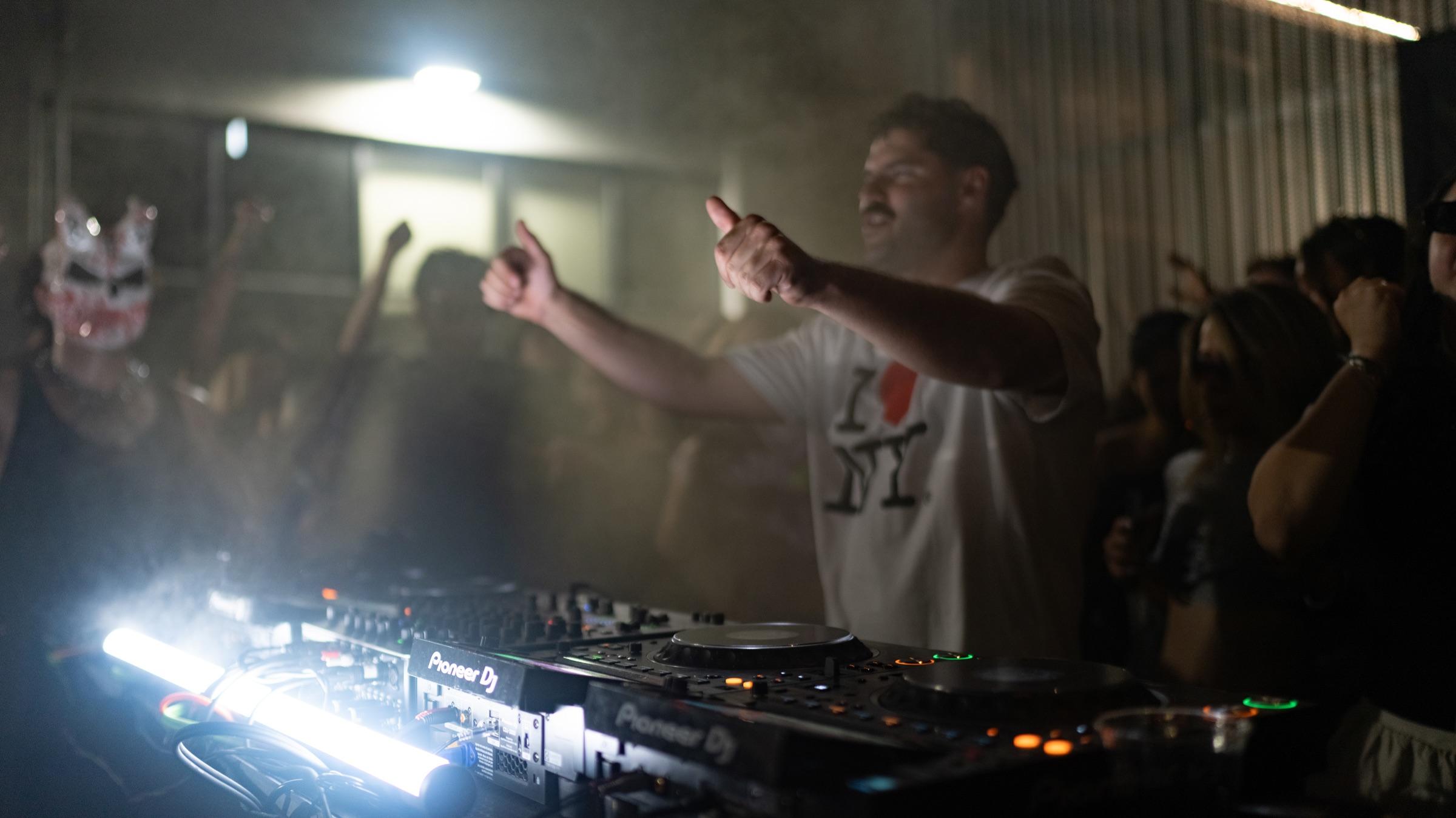 DJ pointing at the crowd, LED light below