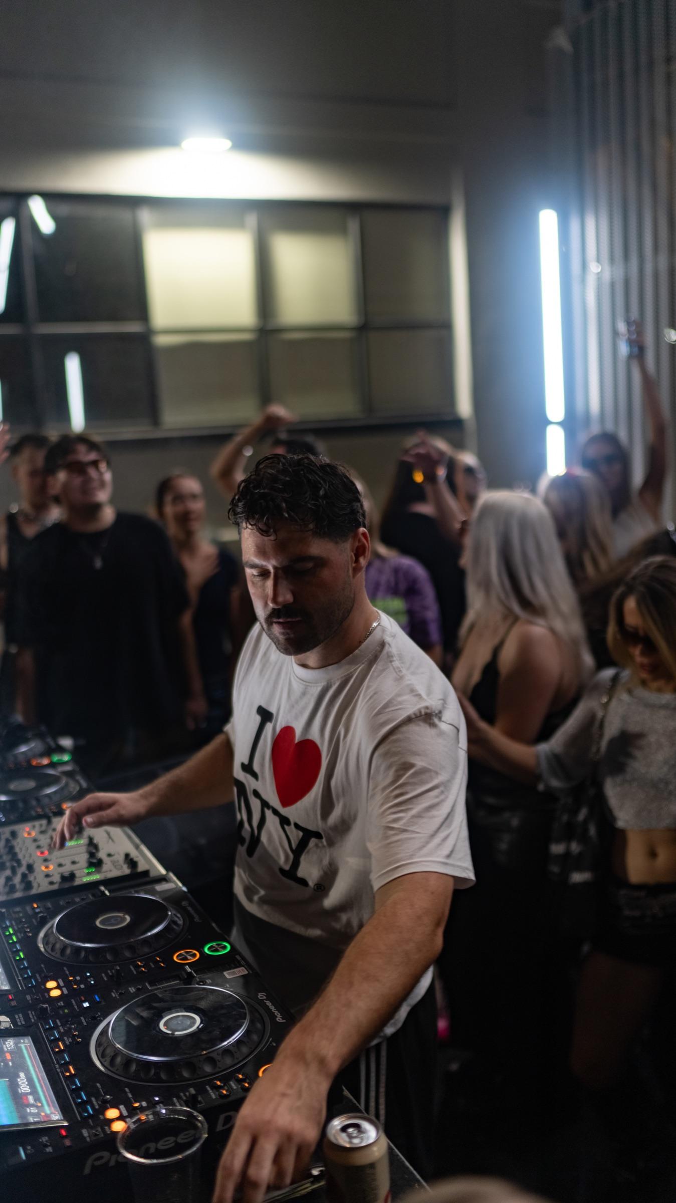 DJ at the decks with the crowd pressed close