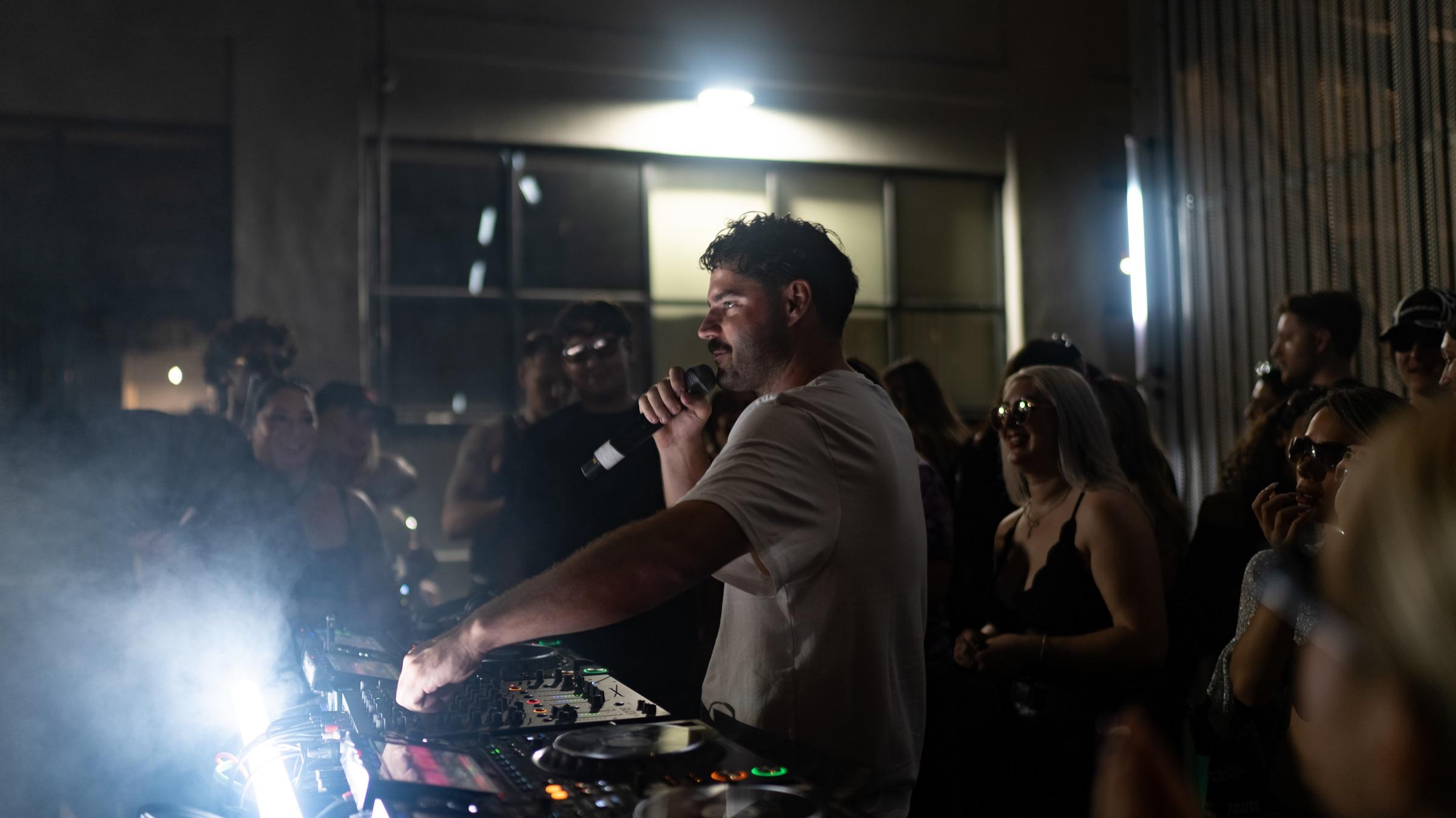 DJ on the microphone through smoke and light