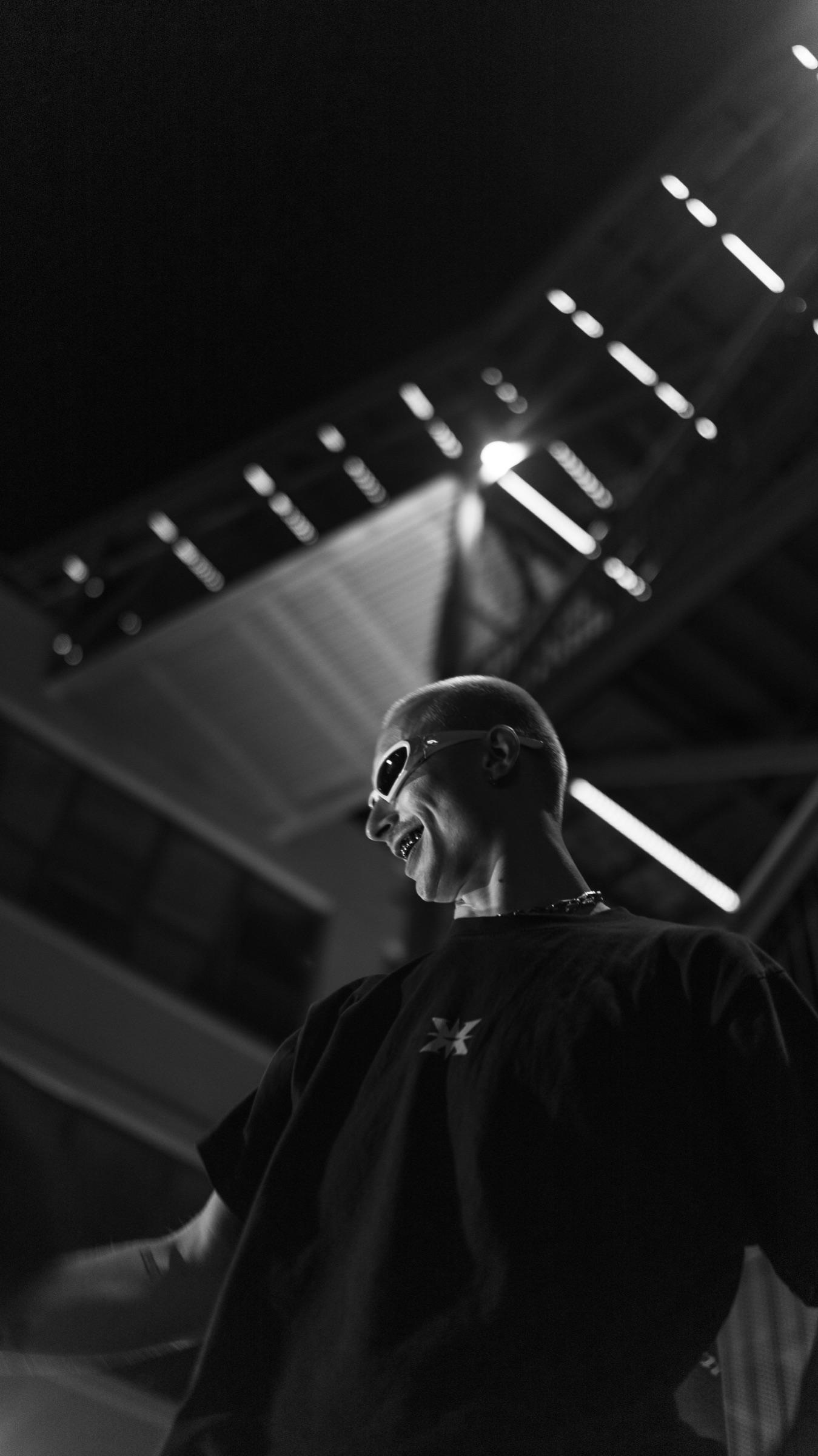 Black-and-white: artist under stairwell lights, shot from below