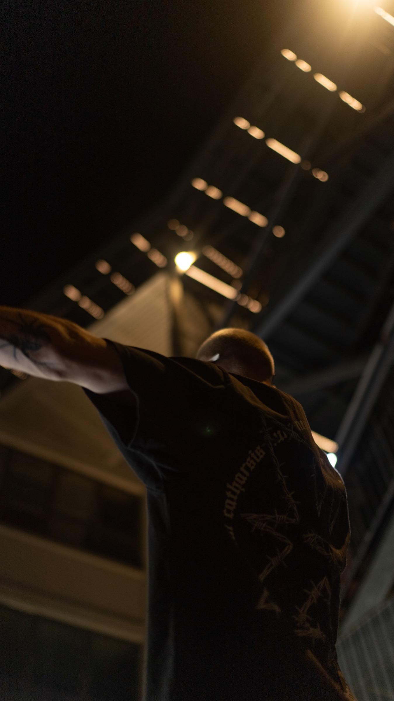 Arms out under warm stairwell lights