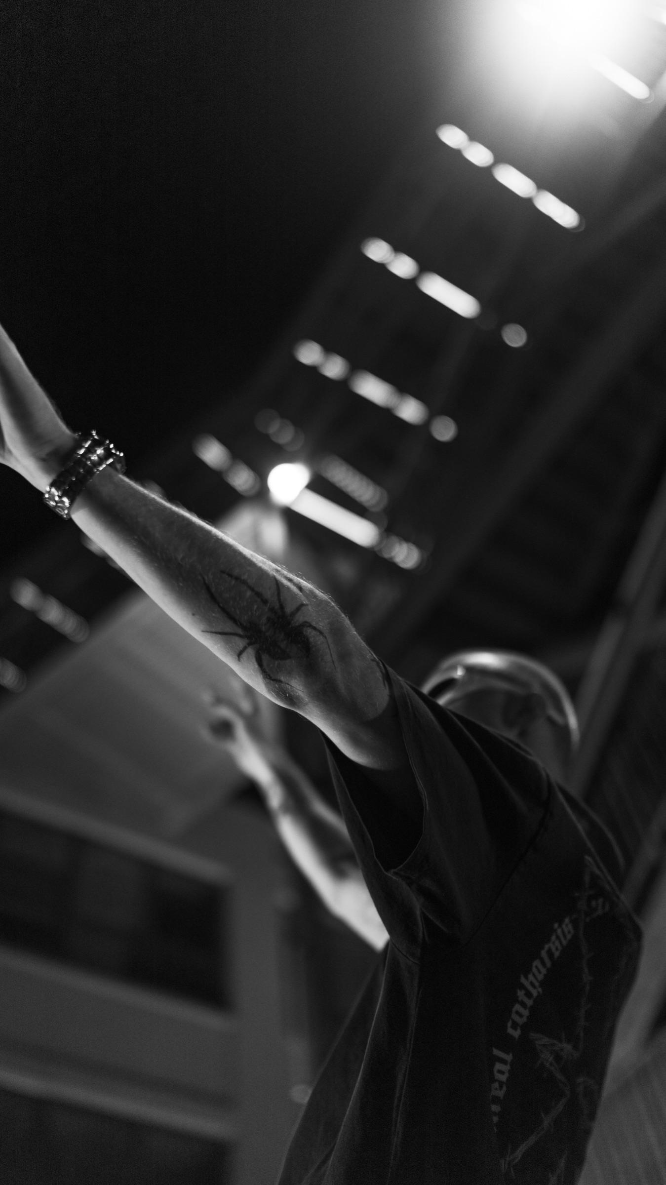 Black-and-white: arms raised under stairwell lights