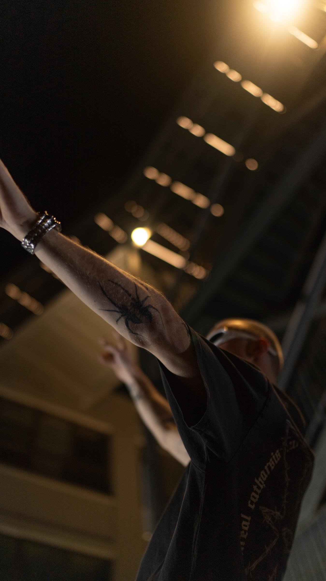 Arms raised under warm stairwell lights