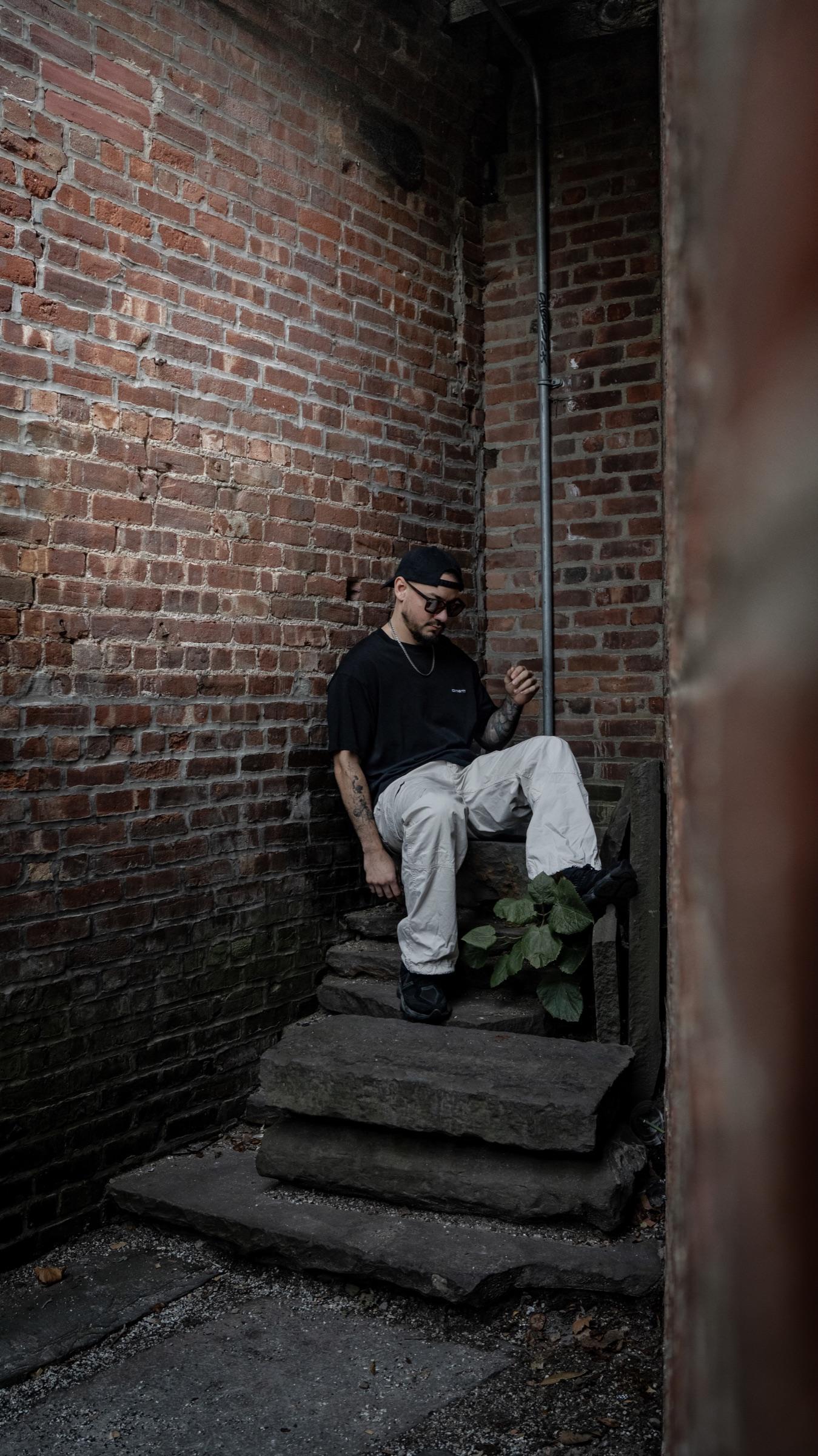 Medina seated on steps at the end of a brick passage