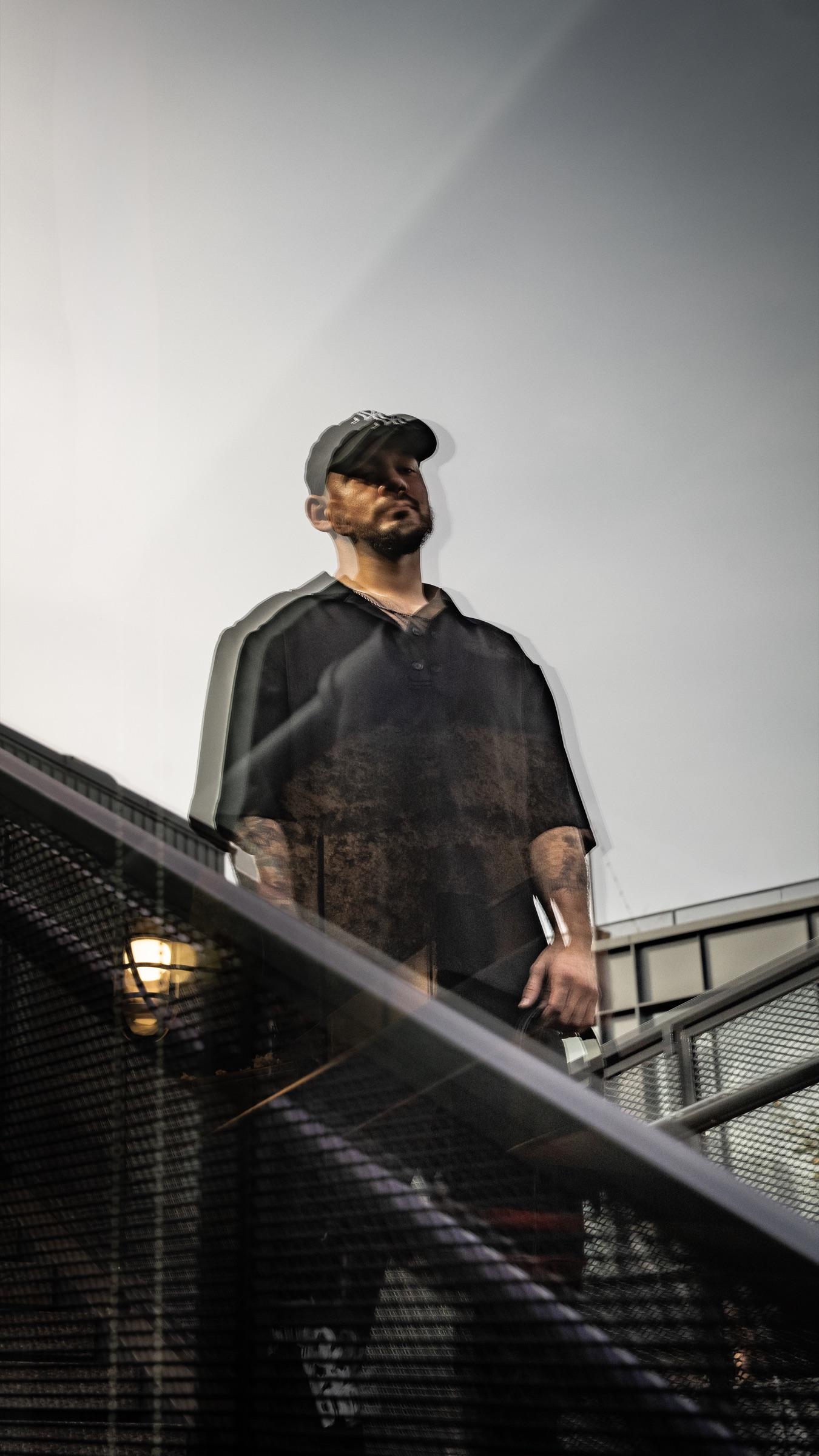 Medina standing on a staircase under a grey sky