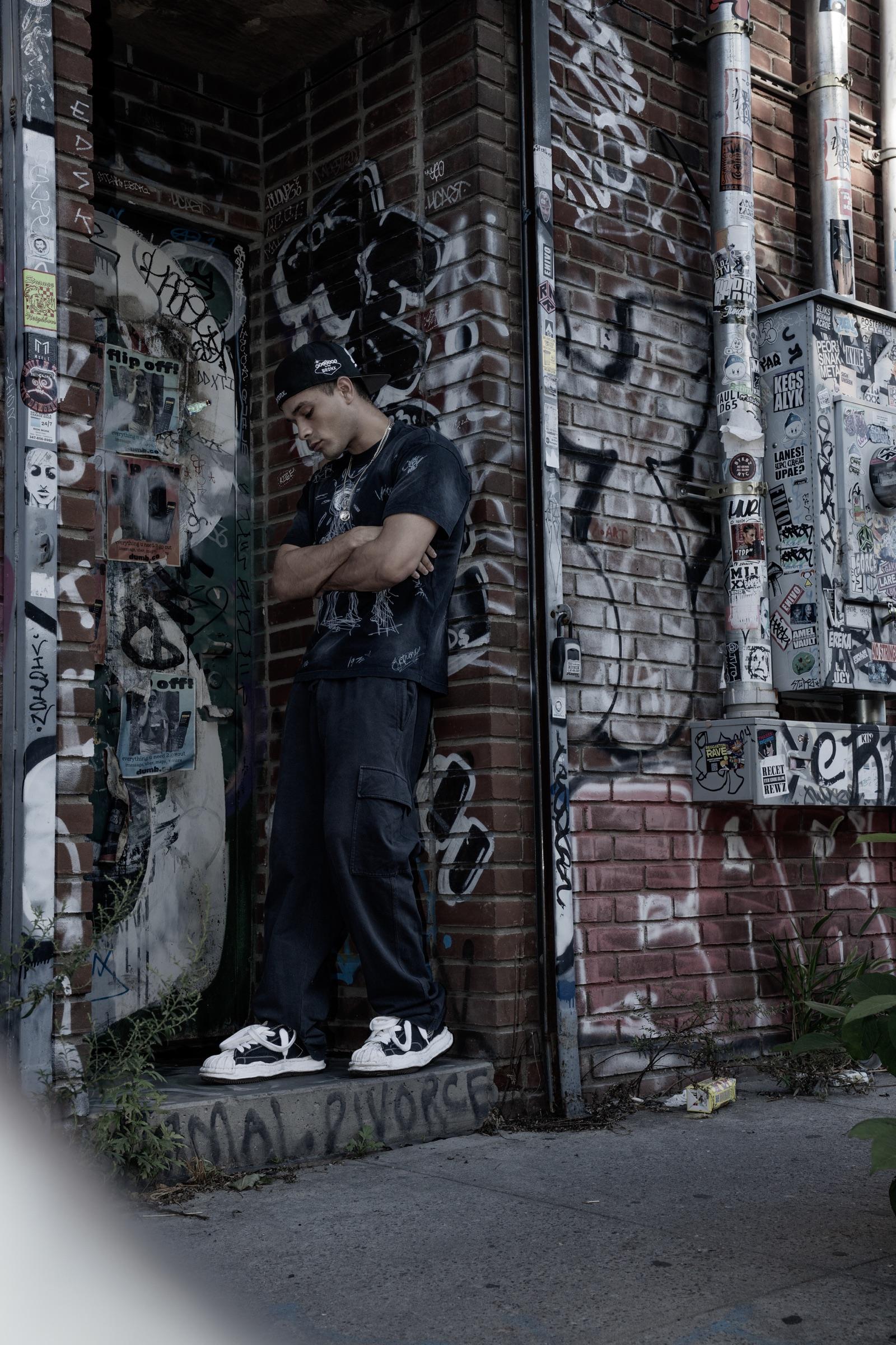 Artist leaning in a graffiti-covered doorway
