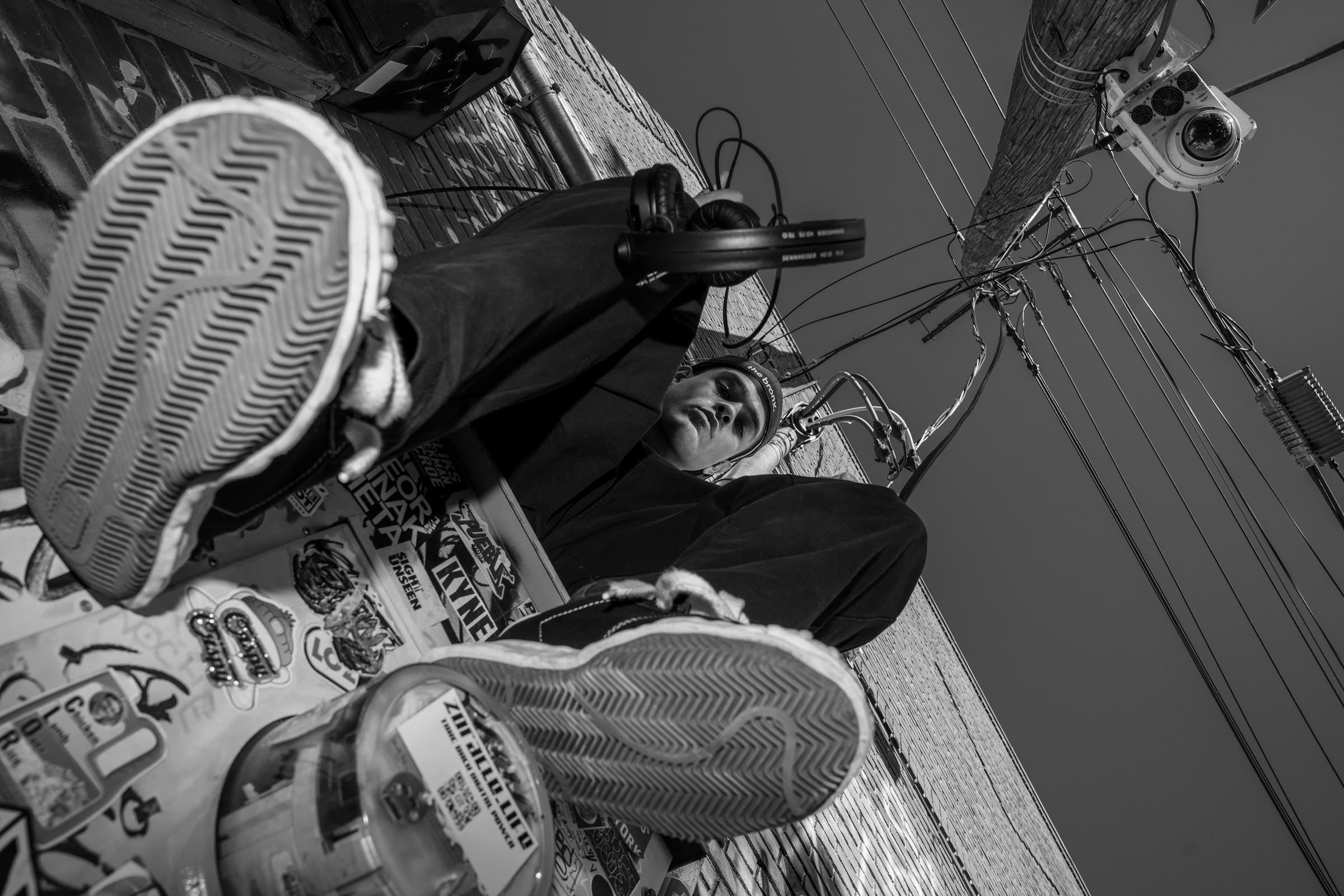 Black-and-white: shot from below, sneaker soles toward the camera