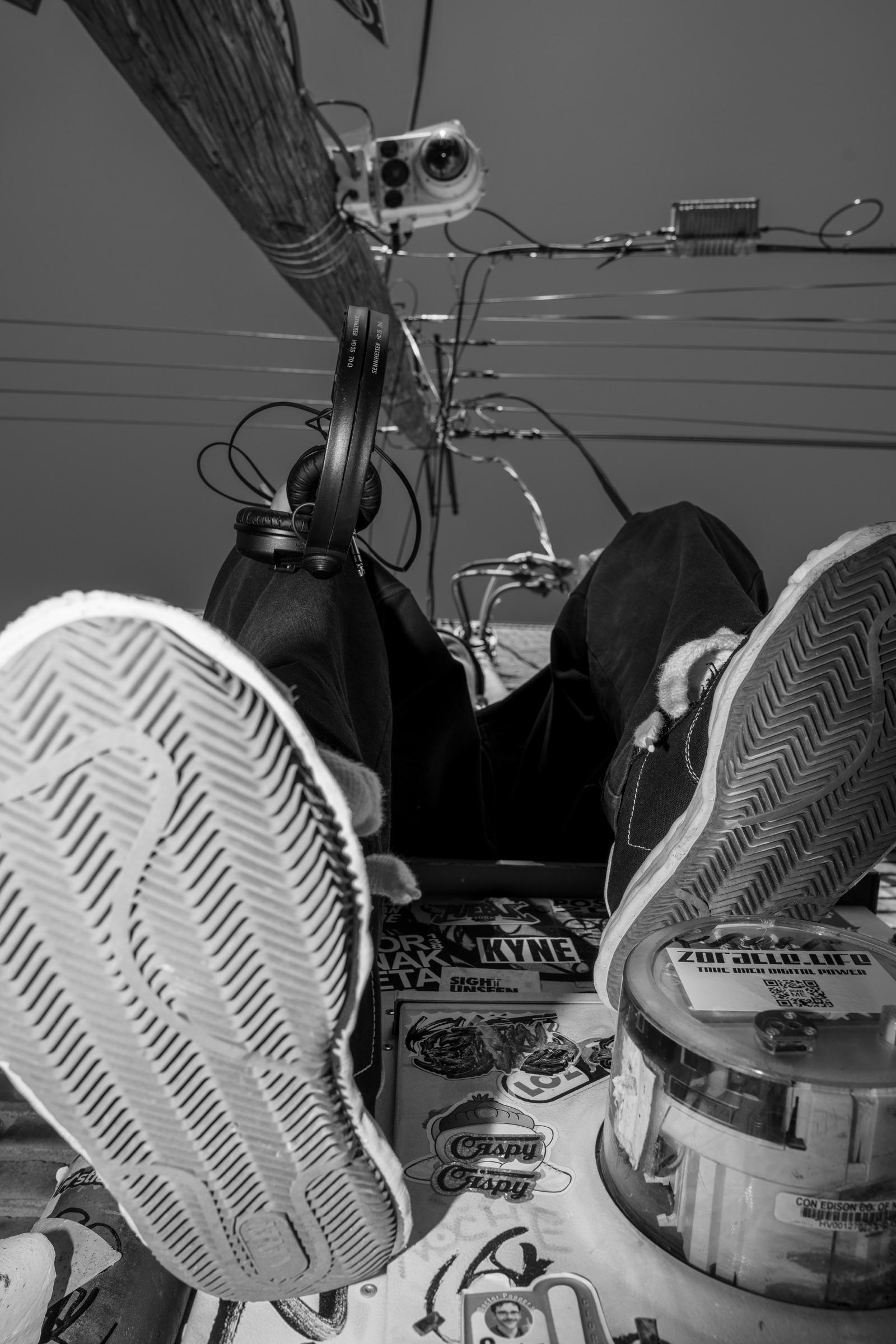 Black-and-white: sneakers close to the lens, wires overhead