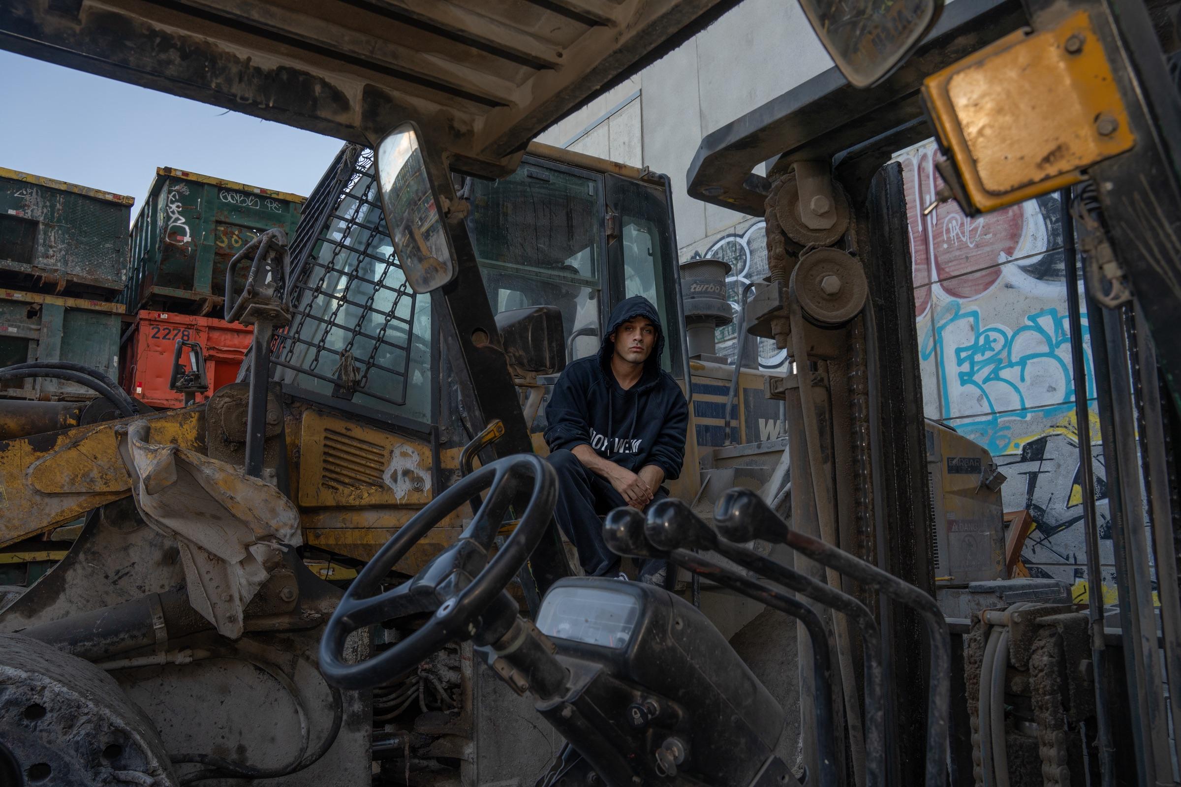 Artist seated in the cab of a construction vehicle