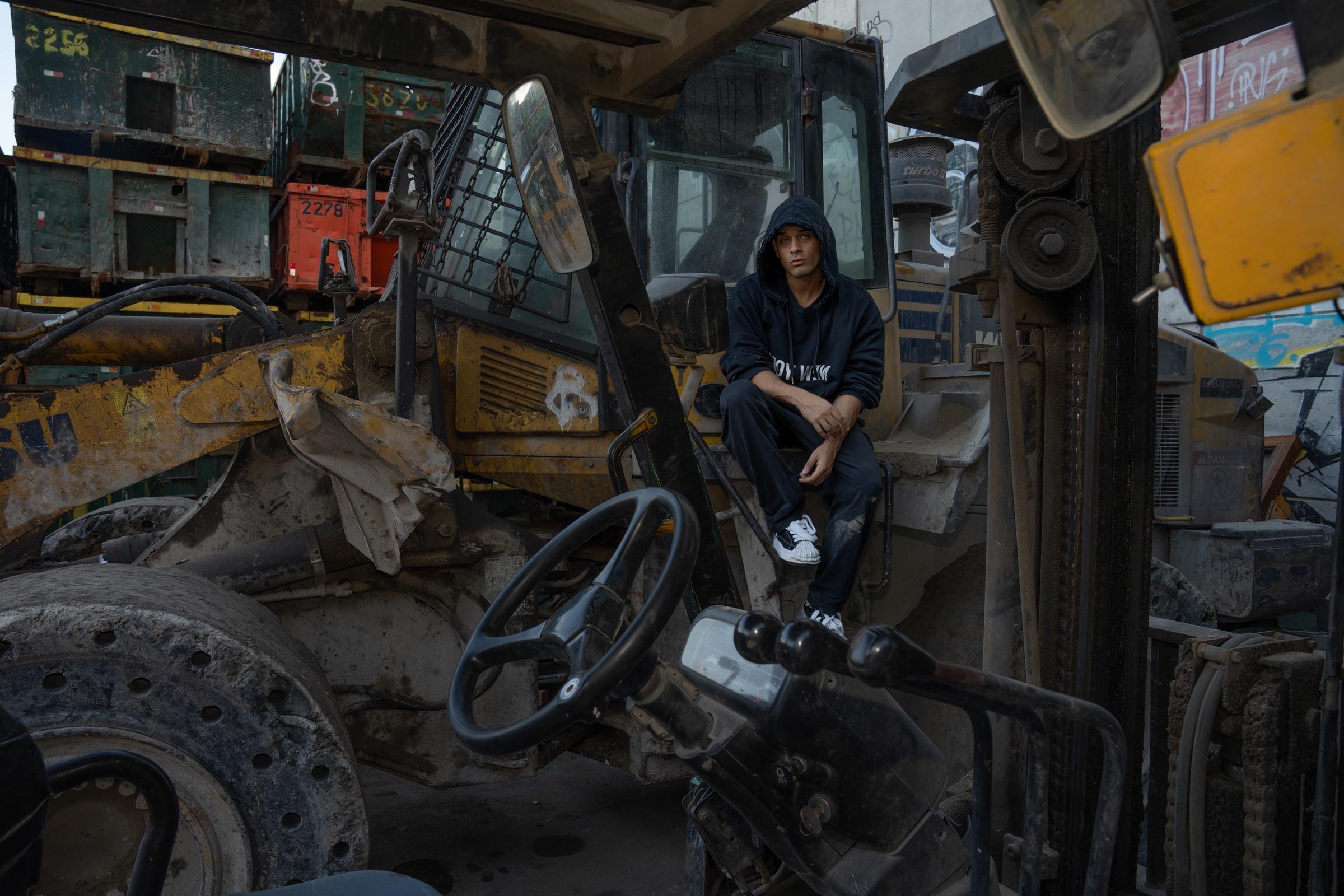 Artist in a construction vehicle cab, wider view