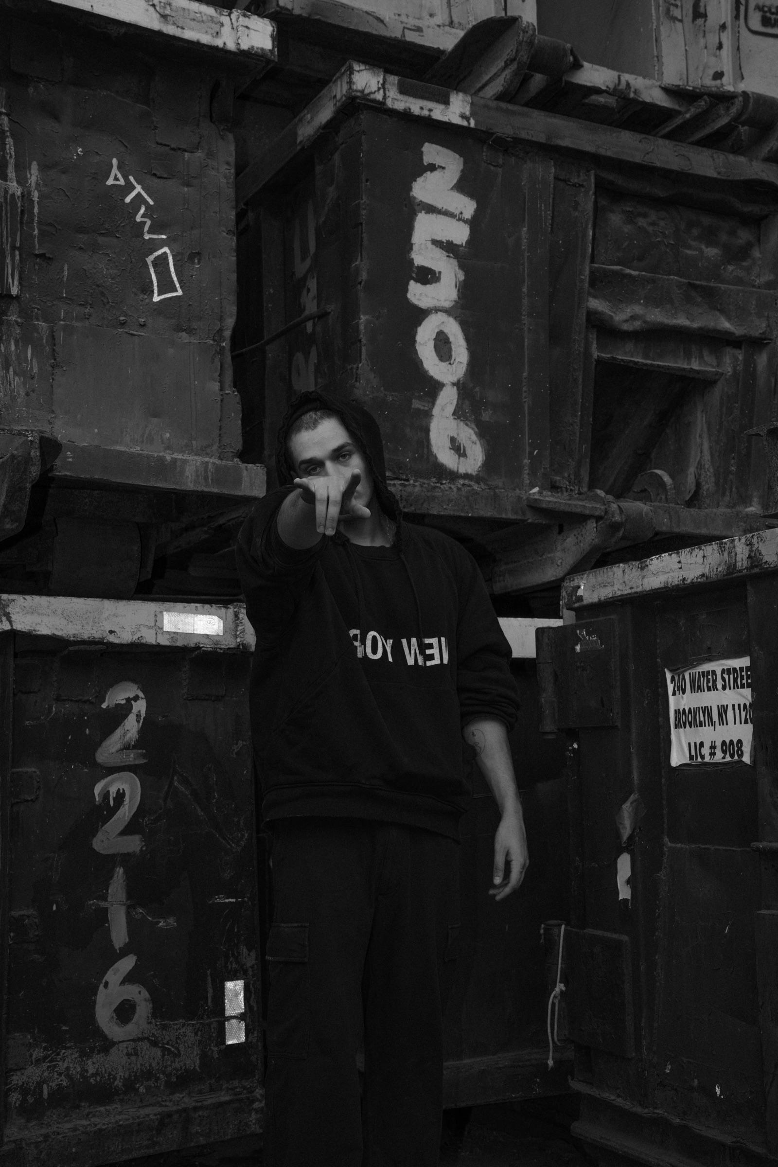 Black-and-white: artist standing between numbered containers