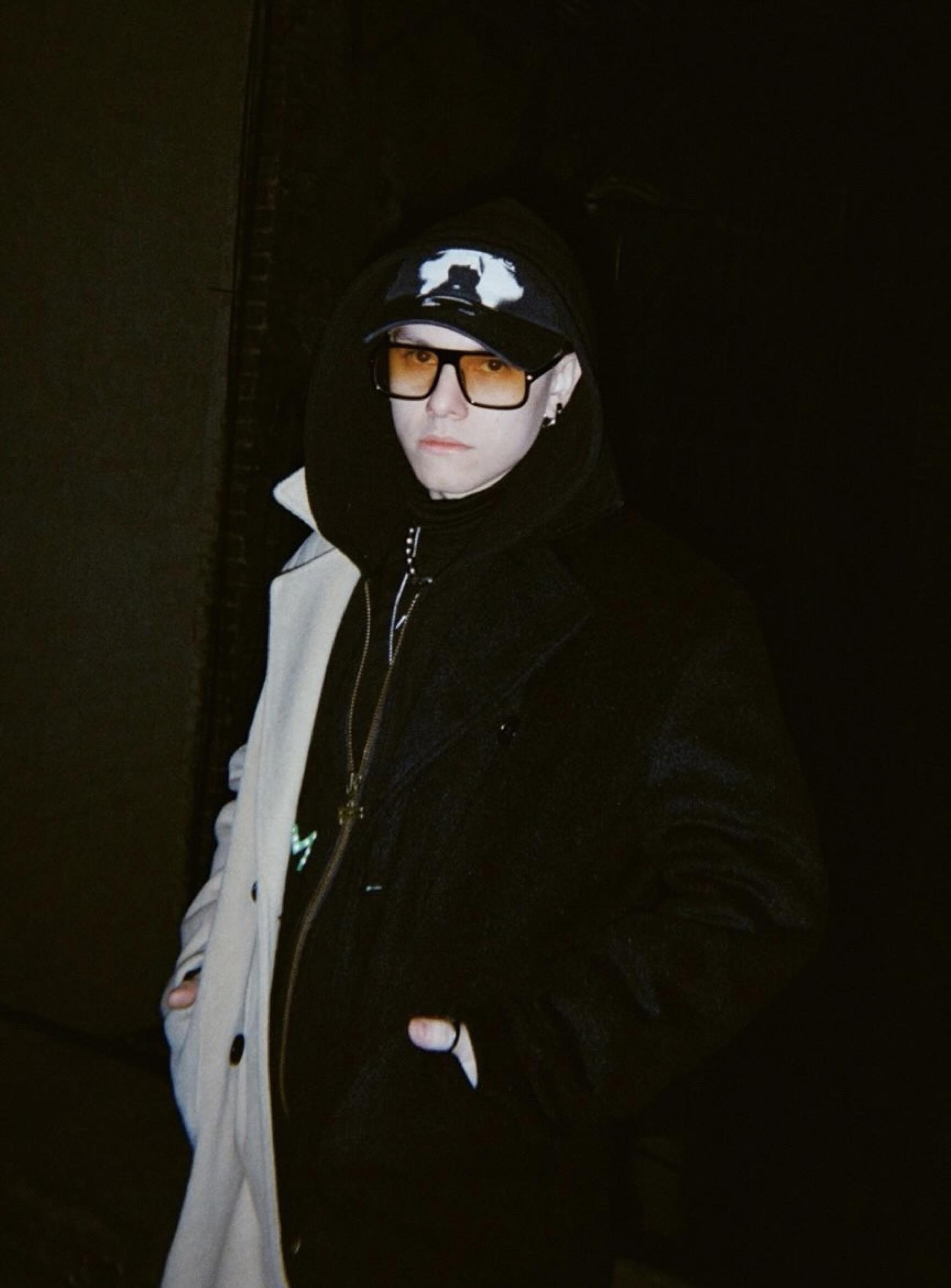 Portrait of Salomon Wize at night in a hood, cap and amber glasses
