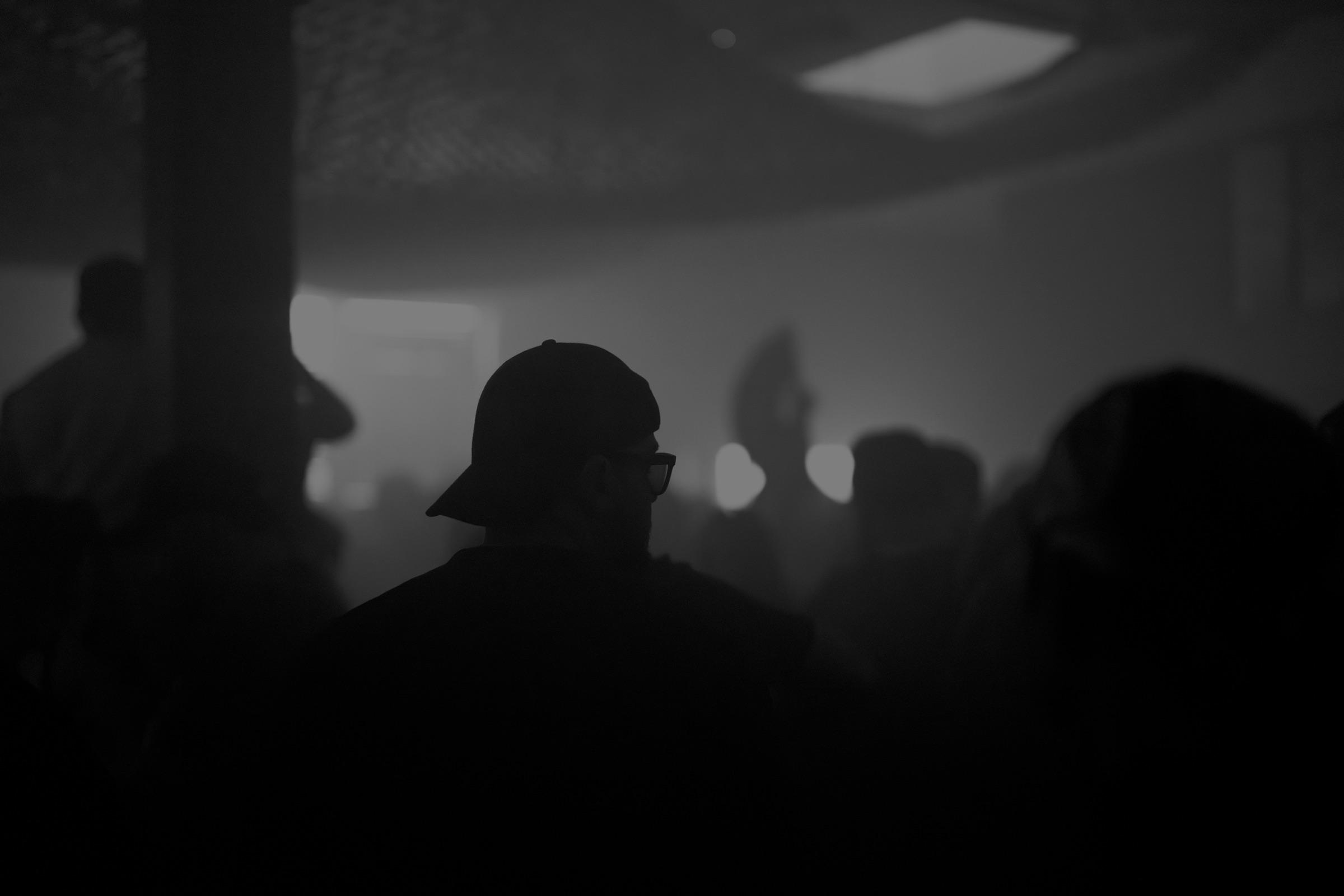 Crowd silhouettes in fog under a low ceiling