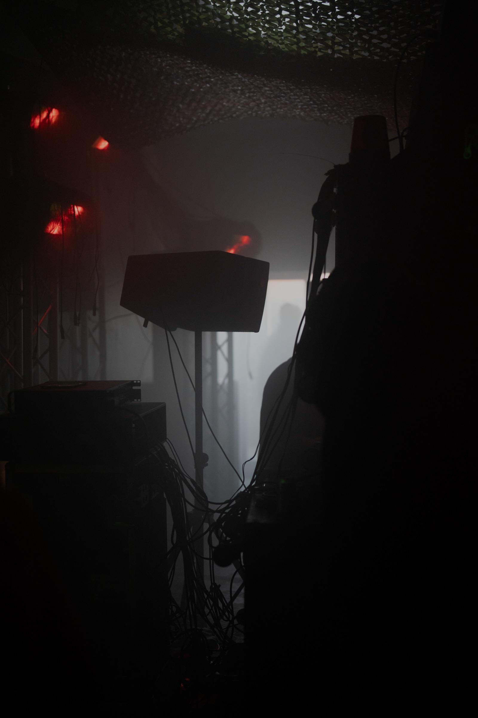 Speaker on a stand with red lights in the dark