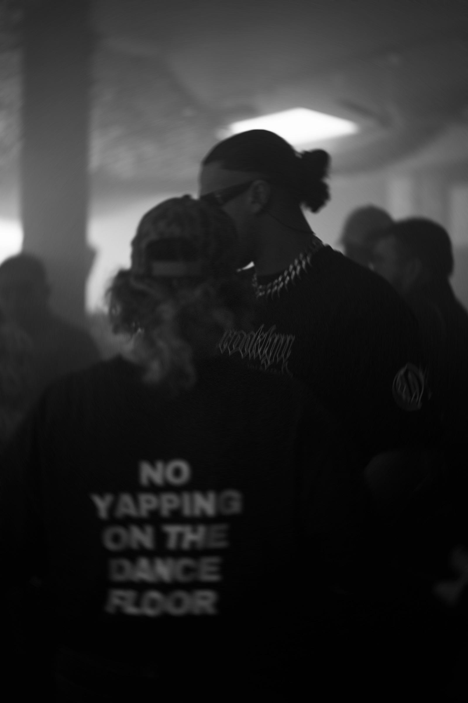 Couple in the crowd, shirt reading No Yapping on the Dance Floor