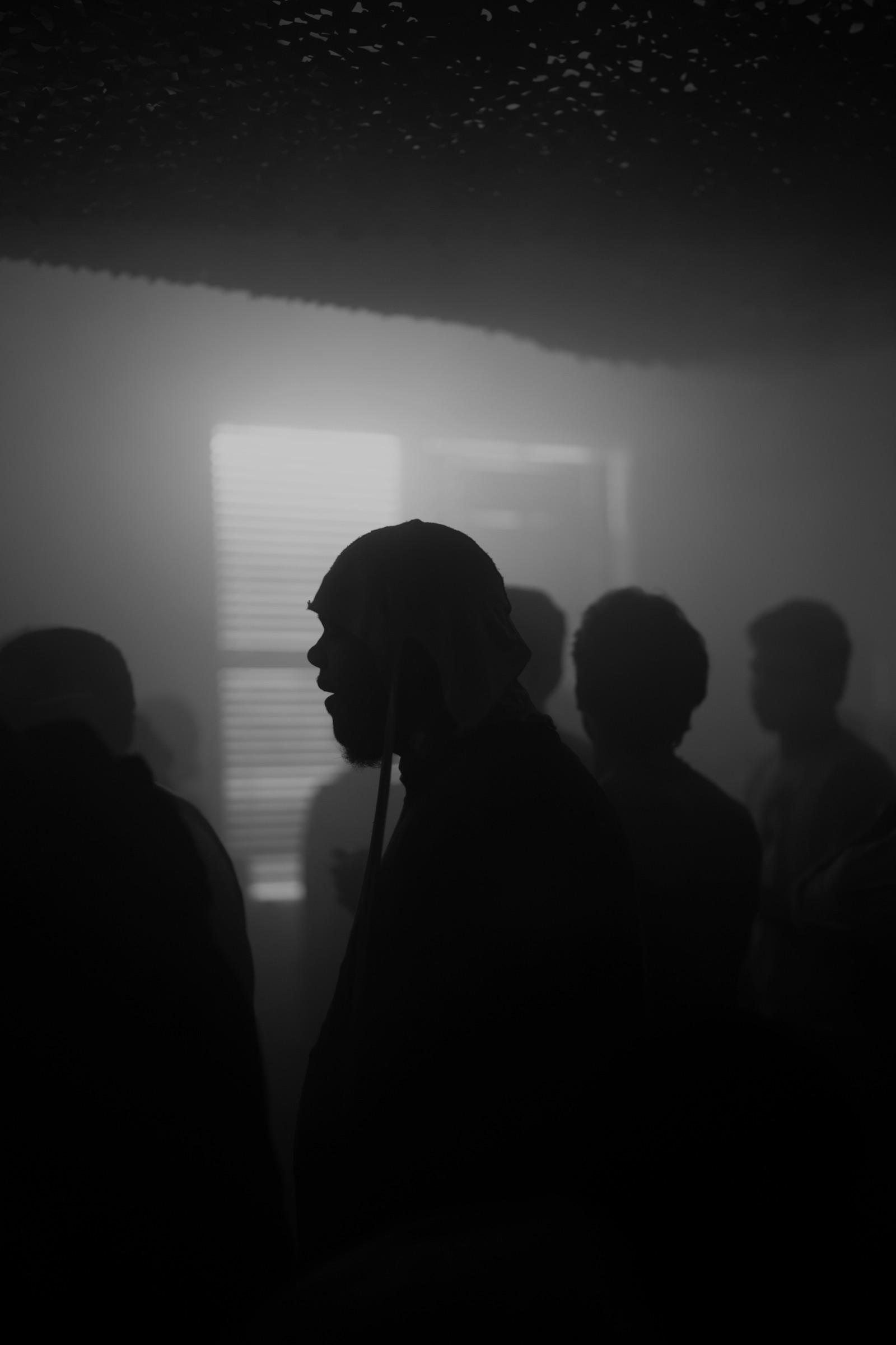 Profile silhouette in a cap among the crowd