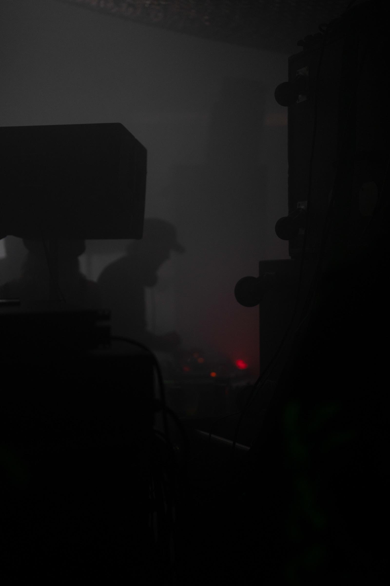 Dark corner by the speakers, faint red light