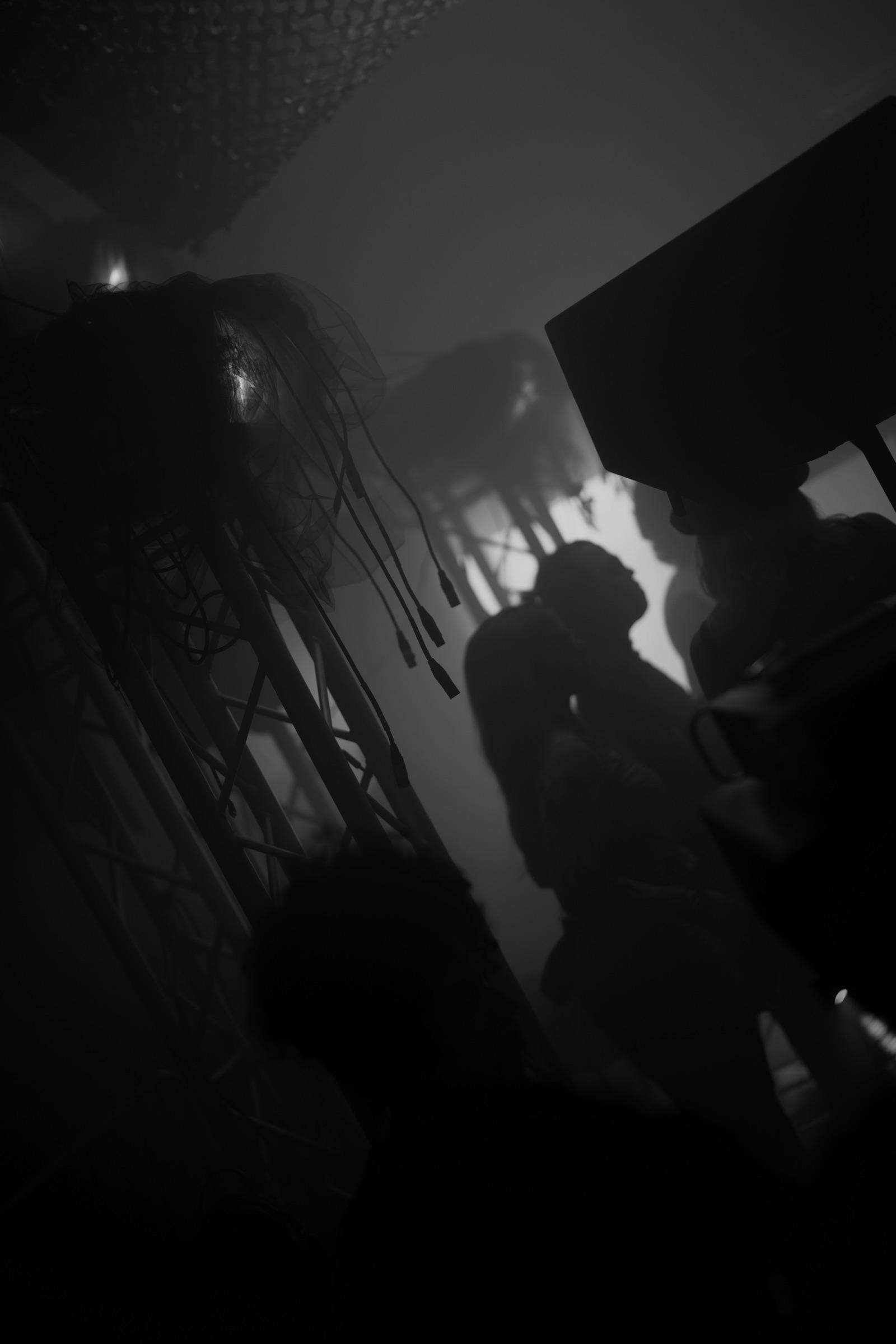 Silhouettes beside a speaker in the dark