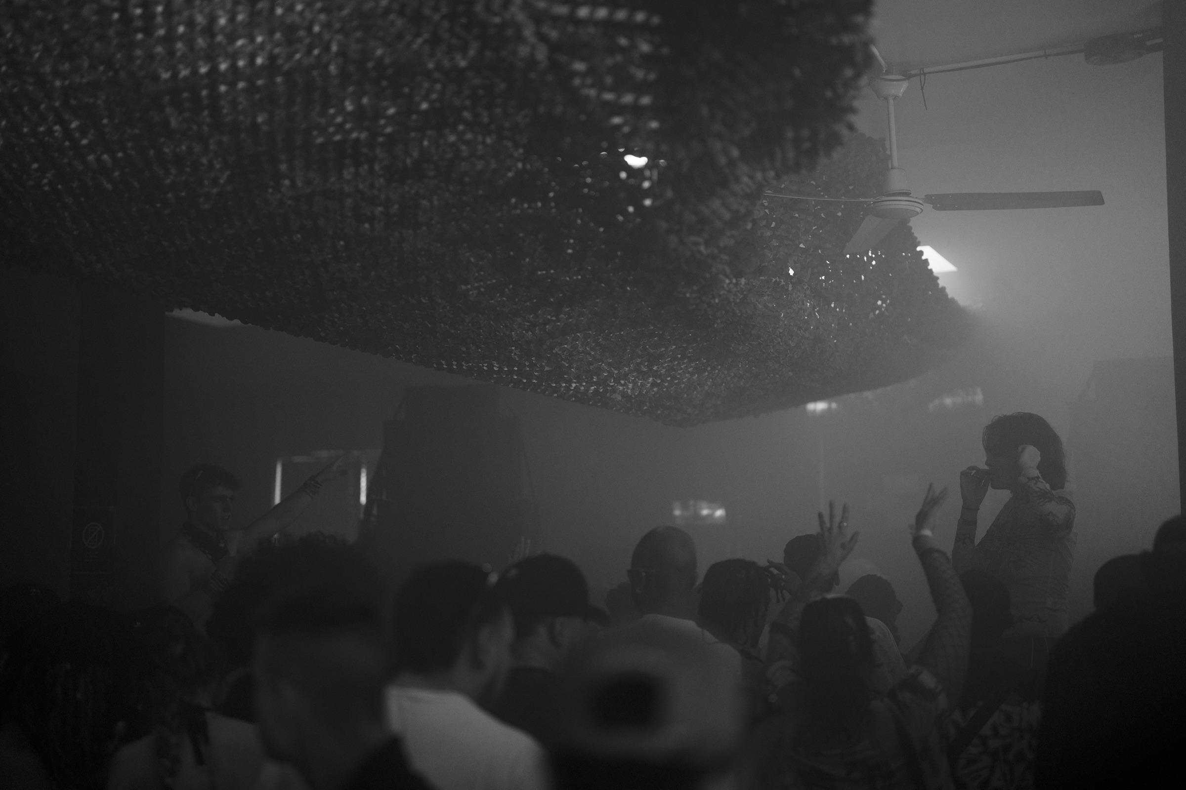 Crowd with hands up under the mesh ceiling
