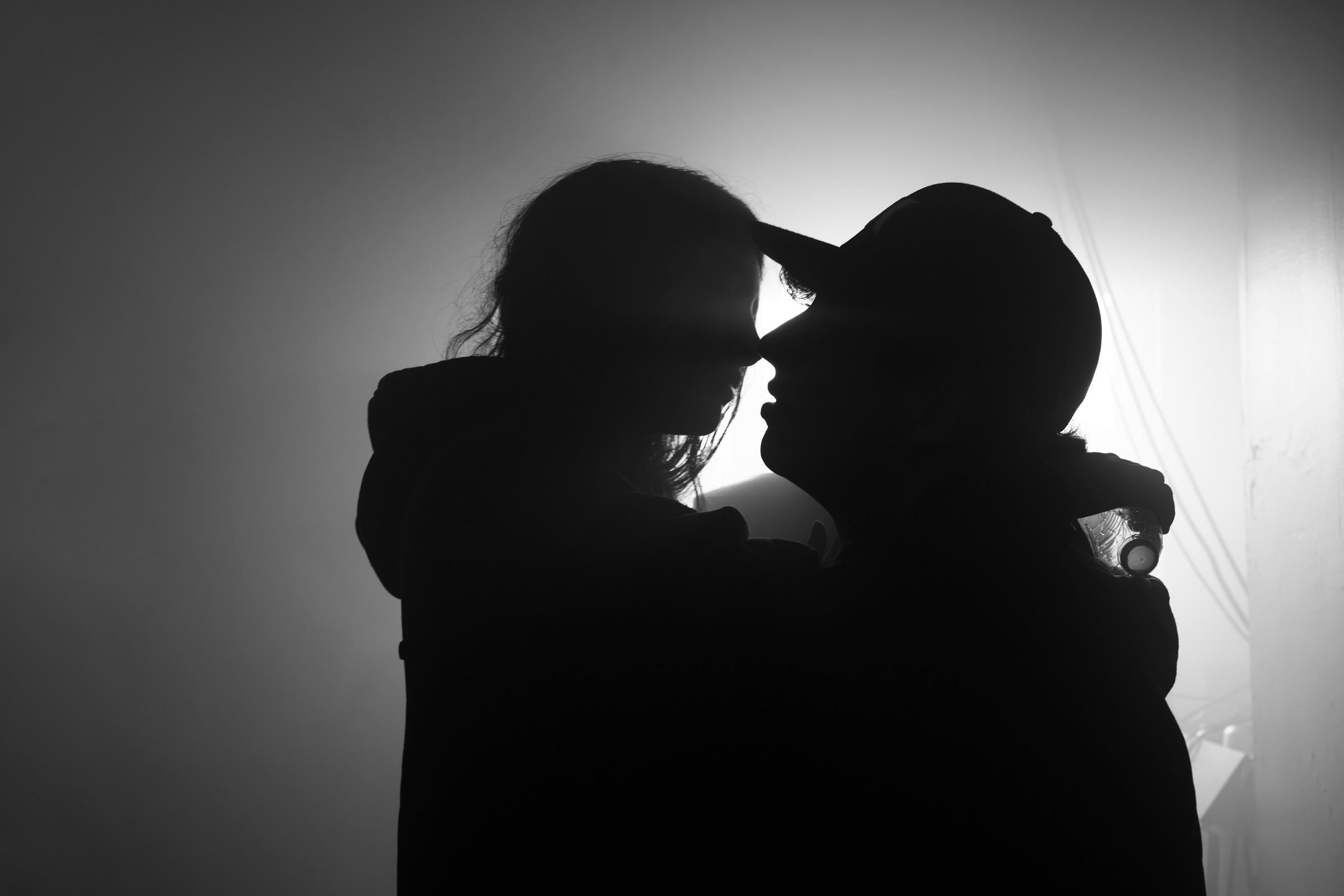 Two silhouettes face to face against white fog