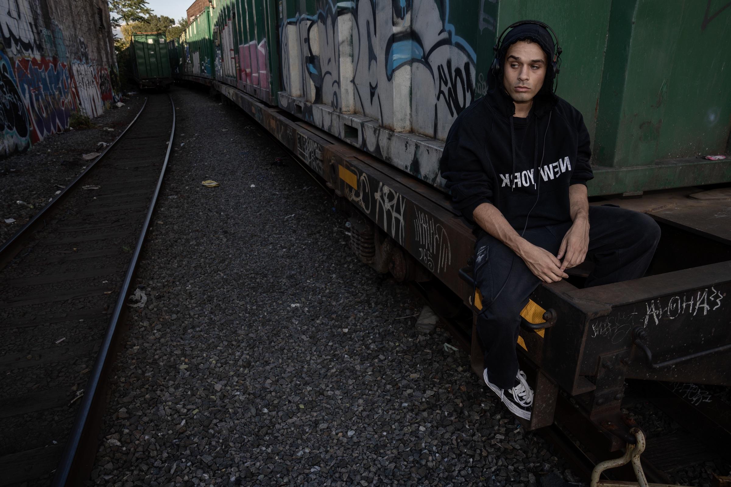 Artist seated beside rail tracks